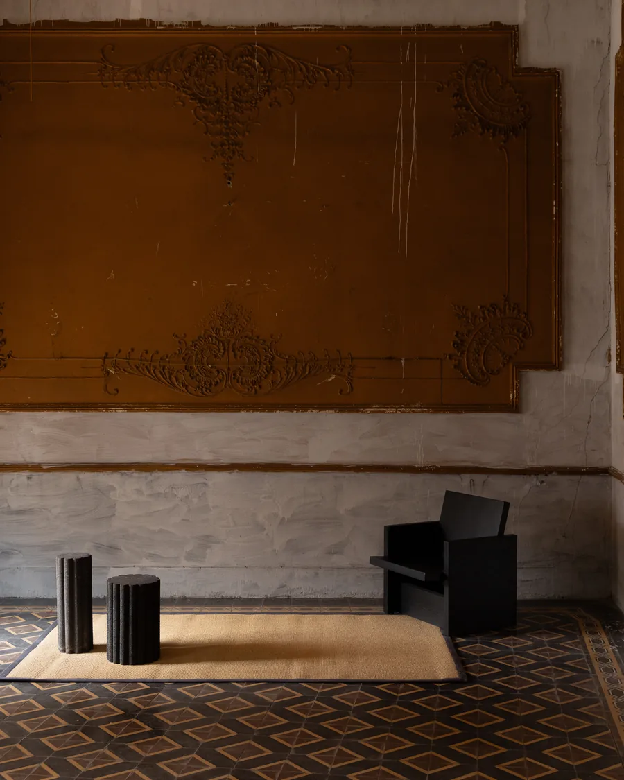 Tapete Panabá 9A con ribete granito en salón con muro ornamentado ocre y silla negra